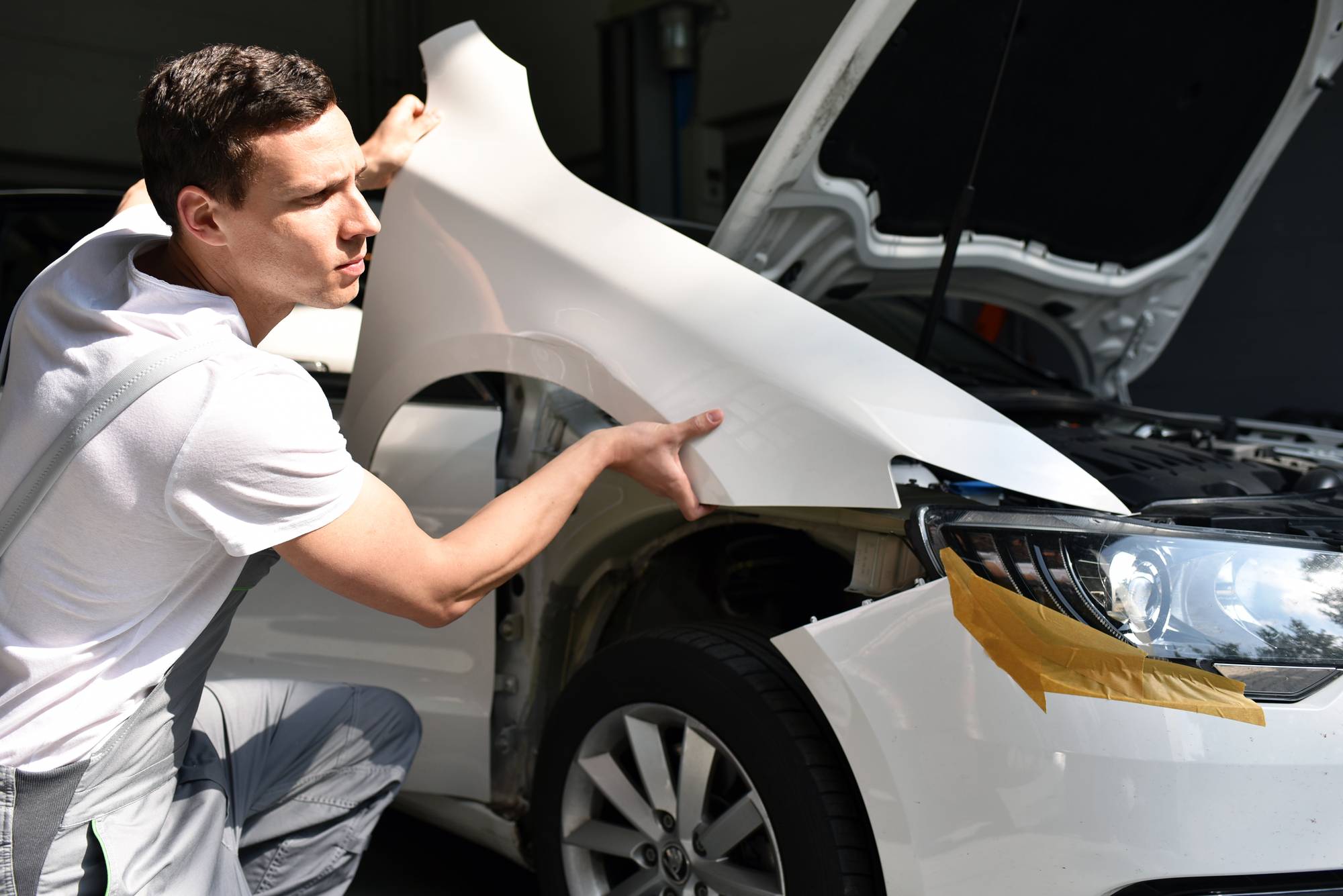 Mechaniker repariert Unfallschaden eines Autos in der Werkstatt