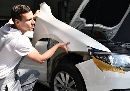 Mechaniker repariert Unfallschaden eines Autos in der Werkstatt